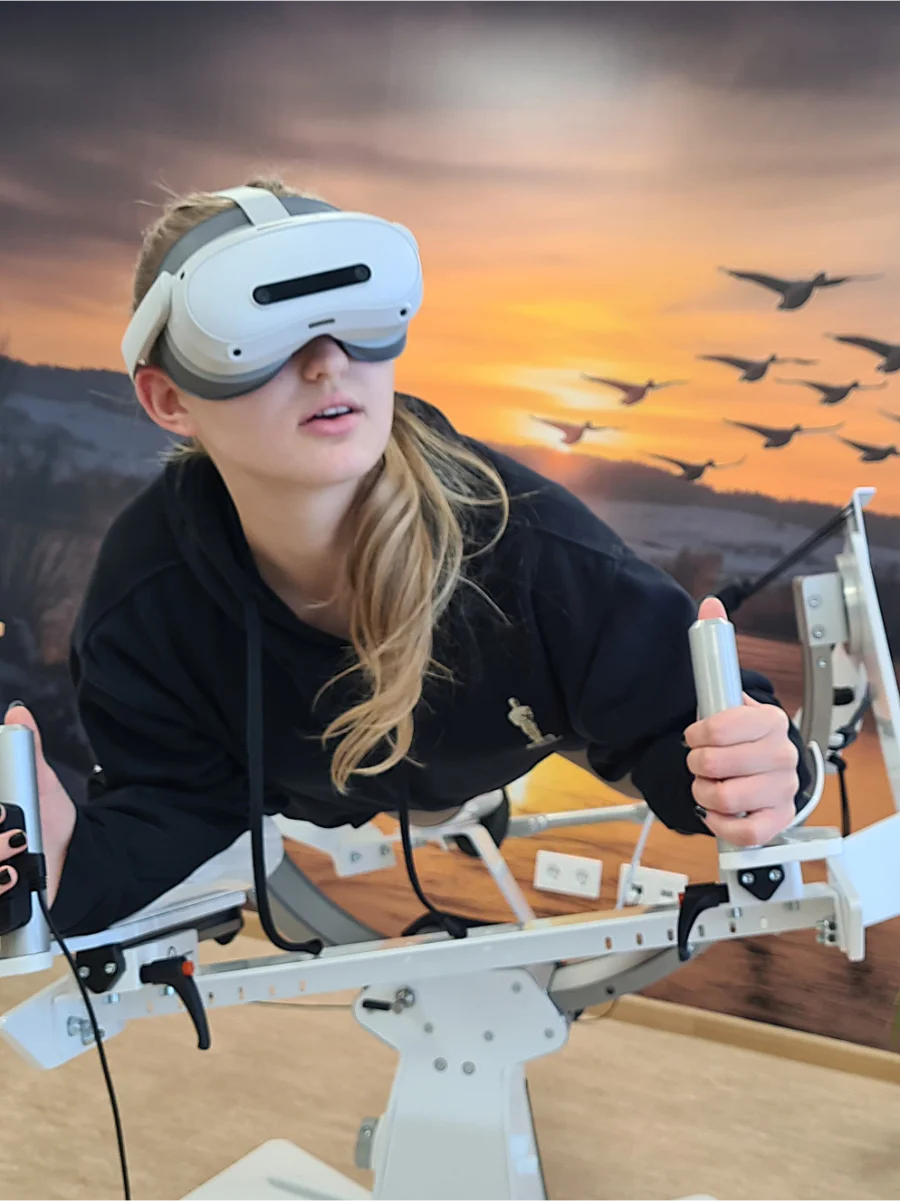 Person mit VR-Brille auf dem ICAROS-Flugsimulator beim virtuellen Flug im Naturbildungszentrum Alfsee